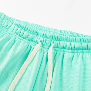 Detail of mint green mesh shorts with elastic waistband and white flat drawstrings