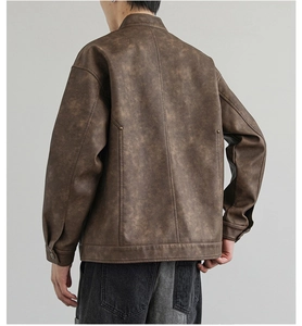 Dettaglio posteriore di una giacca in pelle marrone vintage con borchie e trama invecchiata