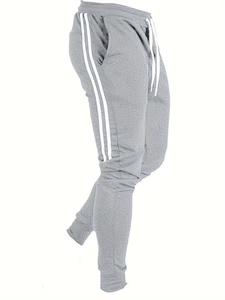 Détail du jogging gris avec bandes latérales, taille à cordon et poignets côtelés