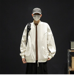 Front detail of a white water-resistant baseball jacket with cargo pockets and stand collar