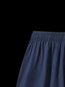 Detail of navy sports shorts featuring a wide elastic waistband and precision stitching