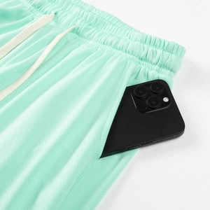 Detail of mint green breathable mesh shorts with drawstring waist and large pockets