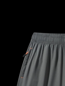 Detail of elastic waistband and side zipper pocket on dark grey quick dry sports shorts