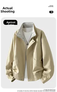 Detail der apricotfarbenen Bomberjacke mit kariertem Kragenfutter und Rippbündchen