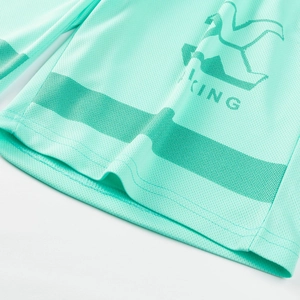 Close-up of mint green breathable mesh fabric with a bird logo and KING print detail