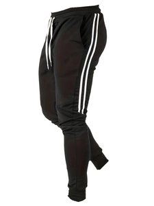 Vue détaillée du pantalon de jogging noir avec doubles bandes blanches et bords-côtes