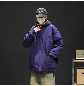 Detail view of purple hooded baseball jacket with large curved pockets and loose fit