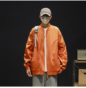 Close-up of orange waterproof baseball jacket with distinctive large arc-shaped front pockets
