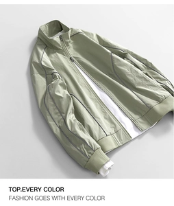 Detail of light green water-resistant jacket with dark contrast piping and stand collar