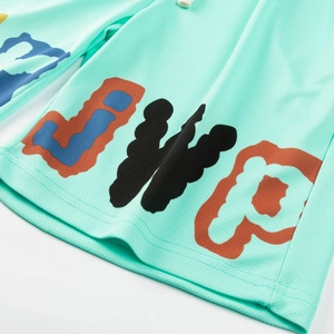 Détail du tissu en maille vert menthe avec lettres colorées et cordon de serrage sport
