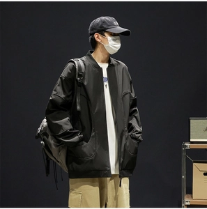 Detail view of water-resistant black baseball collar jacket with curved side pockets