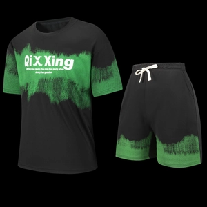 Detail view of black and green tie-dye sports set showing loose t-shirt and drawstring shorts