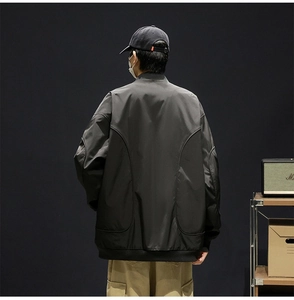 Detail view of the men's black bomber jacket with unique back curved stitching and ribbed hem