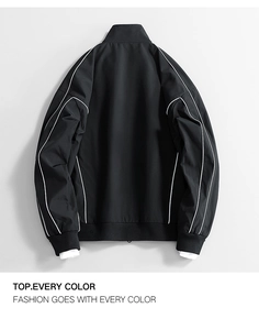 Detail view of black fashion jacket featuring white piping and ribbed knit cuffs