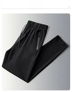 Detail of black ice silk pants featuring elastic drawstring waist and red zipper pocket
