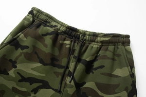 Detail of camouflaged sweatpants showing elastic ribbed waistband and black drawstring