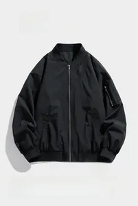 Close-up of a black bomber jacket showing windproof fabric and utility arm zipper pocket