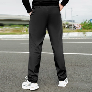Rear view of men's fleece lined winter pants paired with white sneakers in outdoor setting
