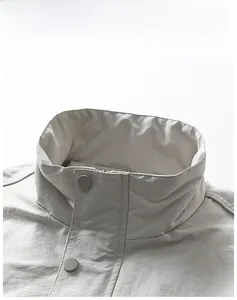 Detail of high stand collar on outdoor jacket with metal snaps and wrinkled tech fabric