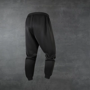 Detailed view of black joggers featuring an elastic waistband and ribbed ankle cuffs