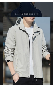 Front view of light grey hooded windbreaker featuring velcro cuffs and stylish printed text