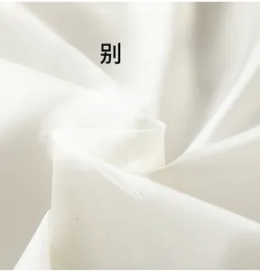 Close-up of white breathable fabric texture showing high ventilation and soft wrinkles