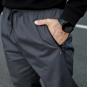 Detail of dark grey fleece pants showing elastic waist with K-SPORTS drawstrings and zipper pocket
