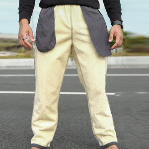 Detail view of winter pants showing the thick beige sherpa fleece lining and elastic waistband