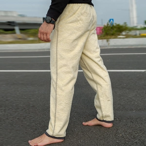Detail view of warm beige sherpa fleece lining and grey hem on men's thermal trousers