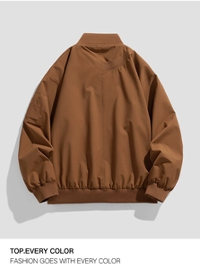 Detail of a brown bomber jacket showing ribbed cuffs and a utility sleeve pocket