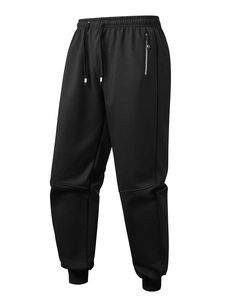 Detail of black fleece jogger with elastic drawstring waist and wave-patterned zipper pocket