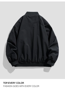 Macro detail of black bomber jacket featuring ribbed collar and sleeve utility pocket