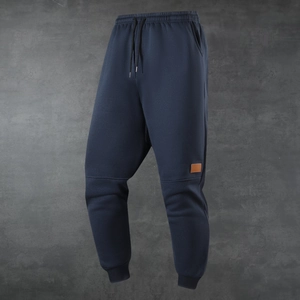 Men's navy blue fleece-lined sports jogger pants with drawstring waist and leather patch