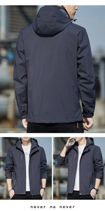 Detail view of navy blue hooded jacket with windproof zip pockets and durable fabric texture