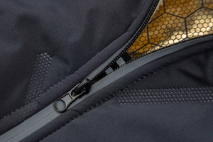 Macro detail of waterproof zipper and gold honeycomb heat reflective lining on jacket