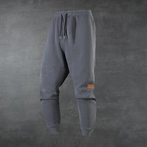 Men's dark grey fleece-lined jogger pants with elastic drawstring waist and leather patch