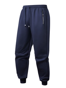 Detail of navy blue joggers showing elastic drawstring waist and zippered pocket details