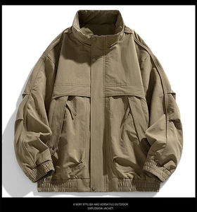Detail of khaki outdoor jacket with stand collar and metallic button windproof flap