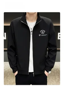 Detail of men's black stand-up collar jacket with silver shield logo and ribbed cuffs
