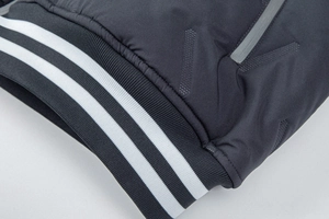 Detailed view of striped ribbed cuffs and quilted windproof fabric on men's winter jacket