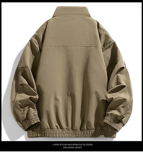 Back view of a khaki outdoor jacket featuring a stand-up collar and pleated seam details