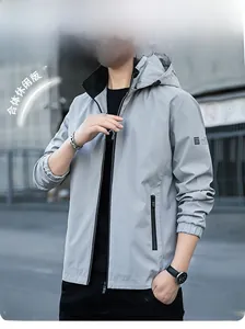 Détail de la veste à capuche gris clair avec poches zippées et écusson sur la manche
