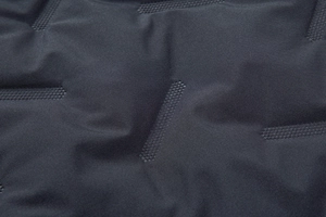 Macro shot of dark gray technical fabric with seamless geometric embossed patterns