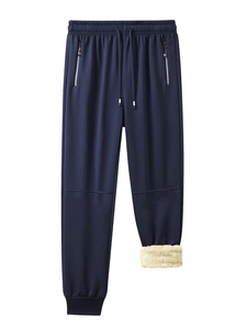 Detail of navy jogger pants showing thick yellow fleece lining and zippered pockets
