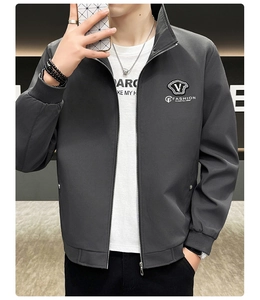 Detailed view of the V-shield logo and smooth windproof fabric on men's gray jacket