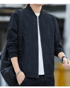 Detail of black bomber jacket featuring subtle tropical leaf patterns and rib-knit cuffs
