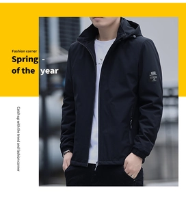 Detail of a black hooded jacket showing a square lettered brand patch on the left sleeve