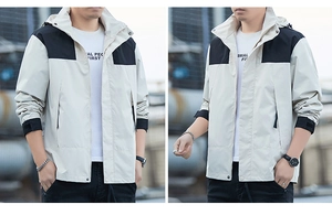 Detail view of men's hooded windbreaker featuring light gray and black color block design