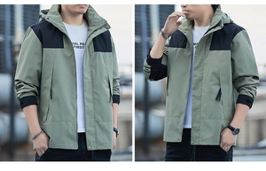 Detail of sage green hooded outdoor jacket with black contrast panels and adjustable cuffs