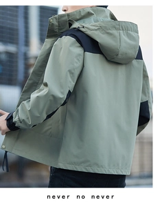 Detail of olive green waterproof windbreaker with adjustable cuffs and hood structure